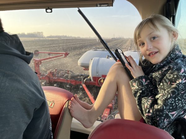 Zoey riding in the tractor with Paul while he planted soybeans this spring. 